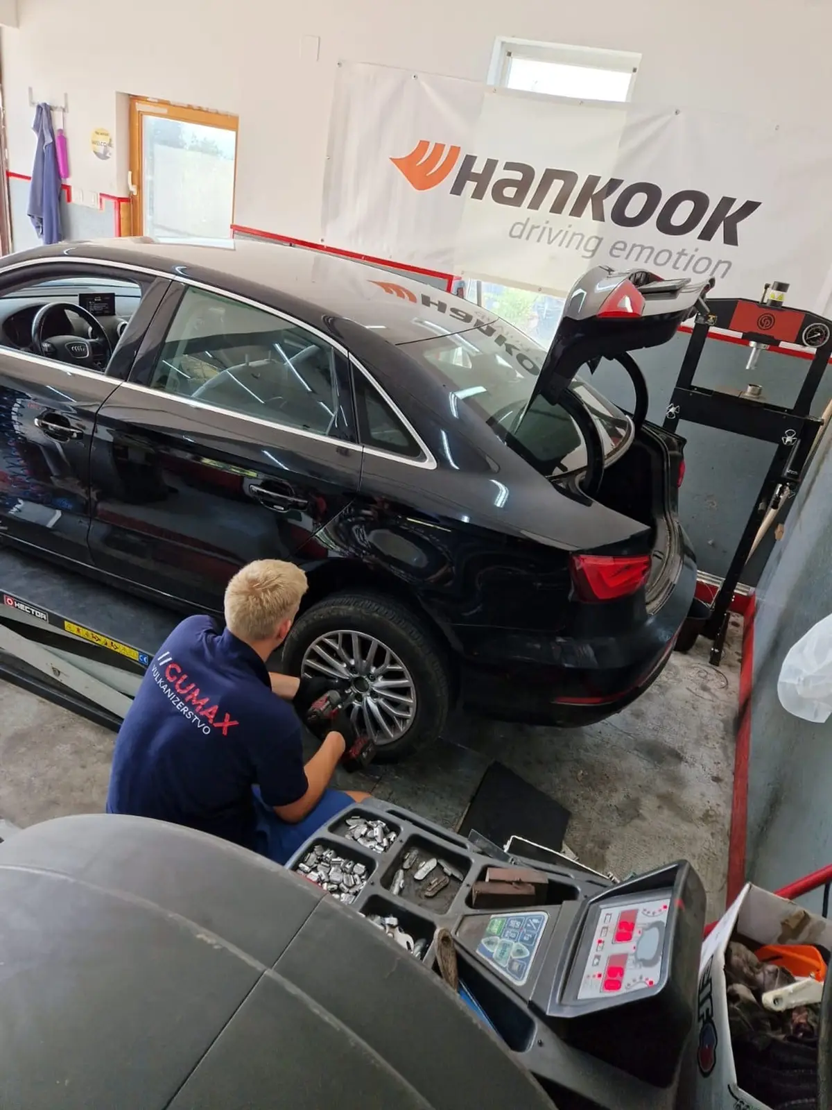 Gumax majstor skida kotač na Audiju A3 tijekom zamjene guma
